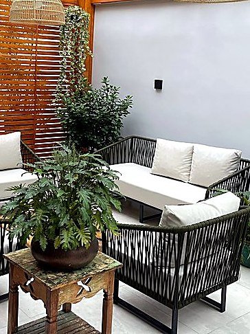 Sofá e poltronas em tricô náutico em varanda com plantas